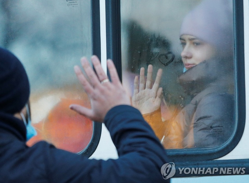 19일(현지시간) 우크라이나 동부 도네츠크에서 한 남성이 버스를 타고 러시아로 대피하는 딸과 작별인사 하고 있다[로이터=연합뉴스]