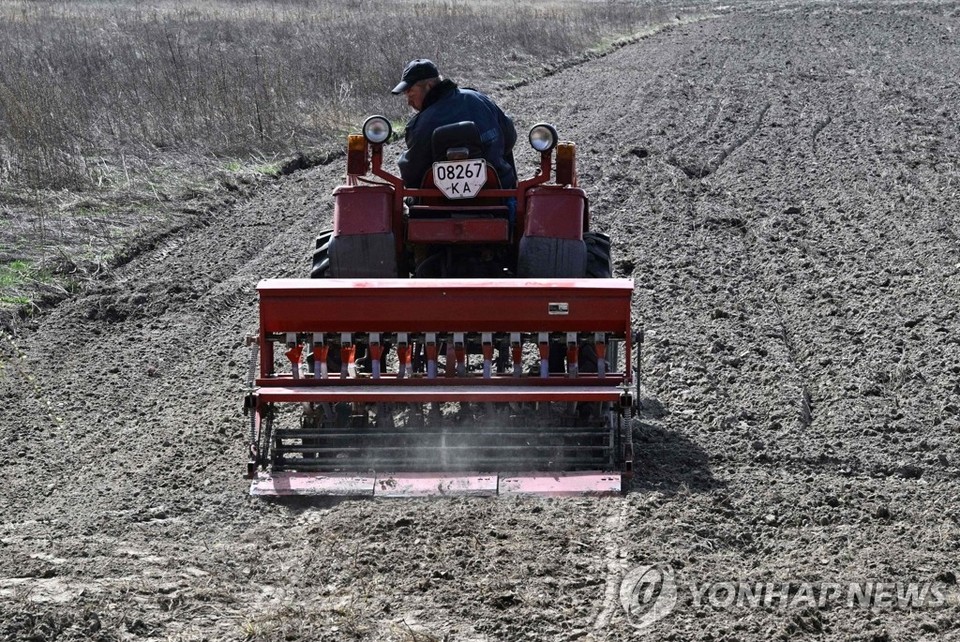 우크라이나를 침공한 러시아군의 공세가 50일째 이어진 14일(현지시간) 키이우주(州)의 경작지에서 한 농부가 농기계를 이용해 귀리 씨를 뿌리고 있다[AFP=연합뉴스]