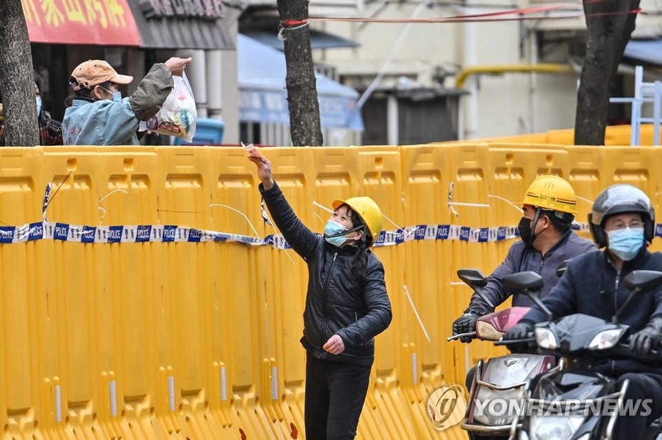 '코로나 바리케이드' 너머로 물건 파는 中 상하이 상인[AFP=연합뉴스 자료 사진]