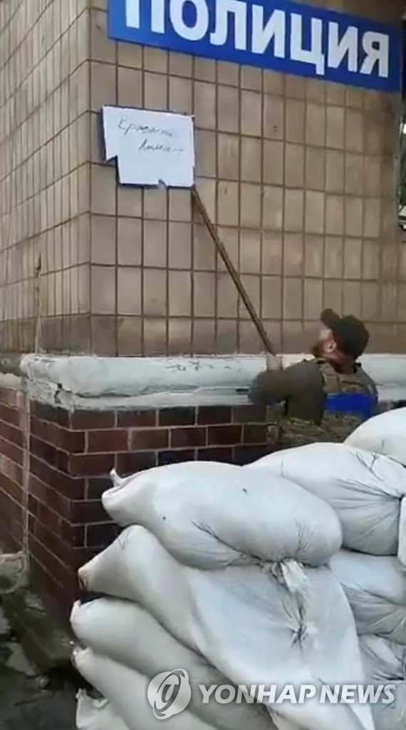 우크라이나 군인이 리만 기념비에 걸린 친러 도네츠크공화국 깃발을 버리는 모습[로이터=연합뉴스 자료 사진]