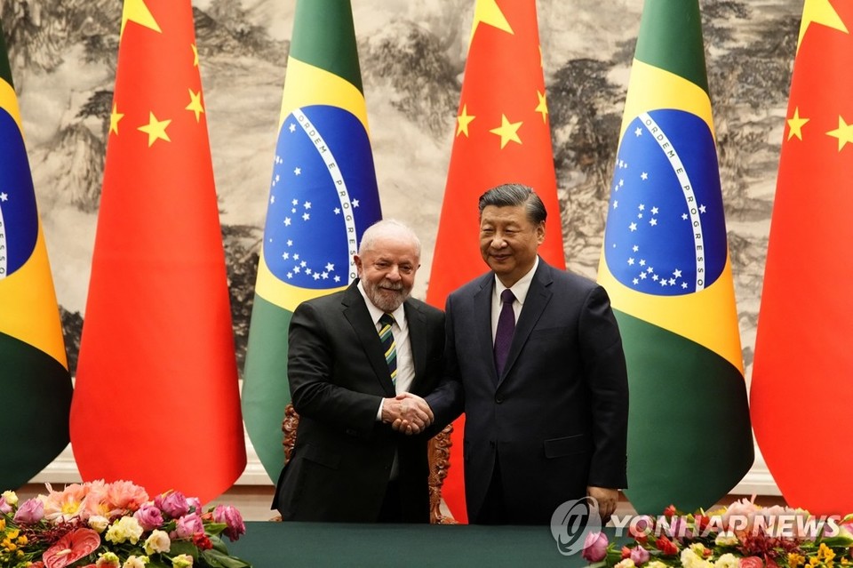 시진핑 중국 국가주석(오른쪽)과 중국을 방문 중인 루이스 이나시우 룰라 다시우바 브라질 대통령이 14일 수도 베이징 인민대회당에서 서명식을 마친 뒤 악수하고 있다[로이터=연합뉴스]