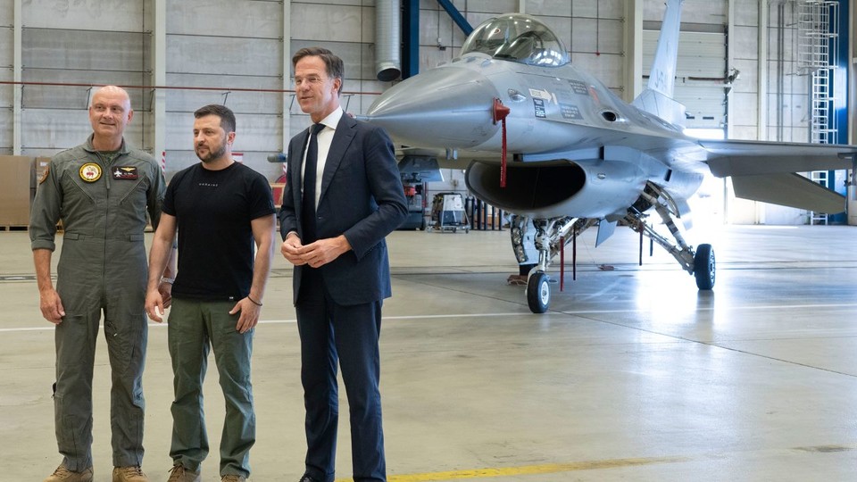 네덜란드 공군기지에 계류 중인 F-16 전투기 앞에 선 볼로디미르 젤렌스키 우크라이나 대통령(가운데)과 마크 뤼터 네덜란드 총리(오른쪽)[AP 캡처]