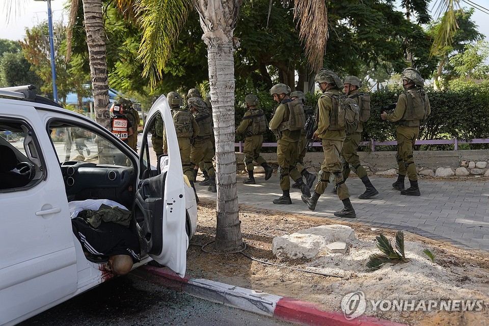 팔레스타인 무장정파 하마스의 로켓 공격에 차 안에서 숨진 이스라엘 주민 옆을 지나는 이스라엘 병사들[AP=연합뉴스]