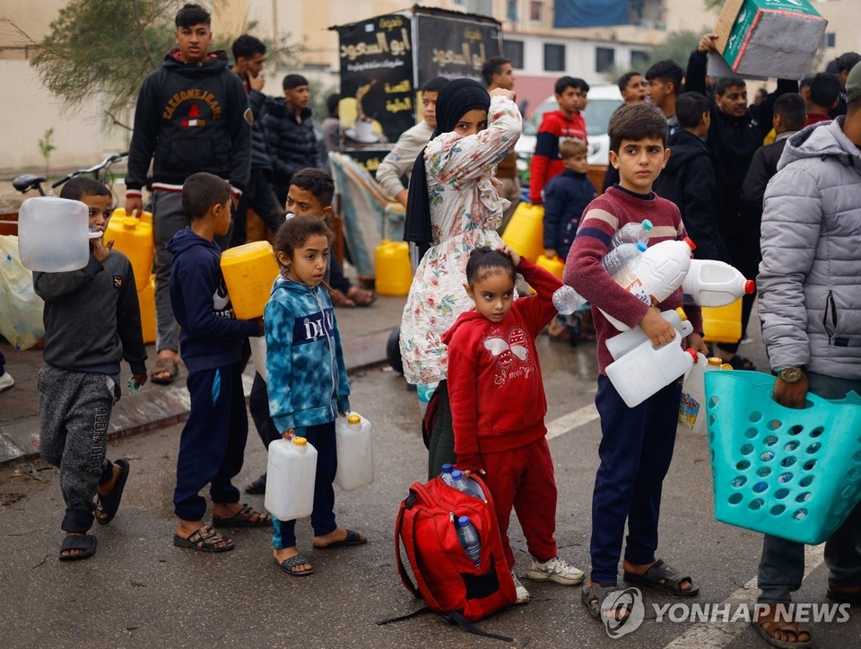 이스라엘과 팔레스타인 무장 정파 하마스 간 교전으로 가자지구 내 식수 부족 문제가 심화하는 가운데 5일(현지시간) 남부 라파에서 어린이들이 물을 받기 위해 줄을 서고 있다[로이터=연합뉴스]