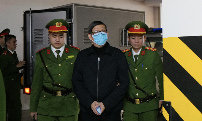 뇌물수수 혐의로 기소된 응우옌 타잉 롱 전 베트남 보건부장관(가운데)이 12일 재판정으로 들어서고 있다[Vn익스프레스 캡처]