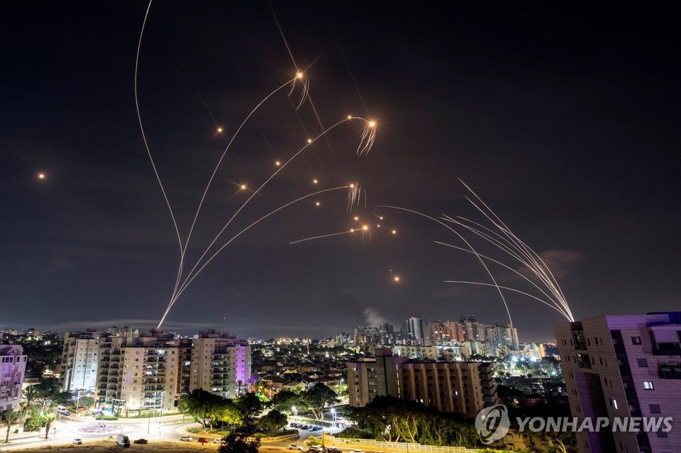 팔레스타인 가자지구에서 날아온 로켓포탄(오른쪽)과 이를 요격하기 위해 방공망 아이언돔에서 발사된 요격 미사일(오른쪽)의 궤적[로이터=연합뉴스 자료 사진]