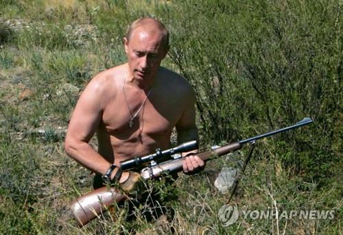 블라디미르 푸틴 러시아 대통령이 2007년 7월 15일 시베리아 산악지대에서 웃옷을 벗은 채 총을 들고 사냥하고 있다. [EPA=연합뉴스 자료 사진]
