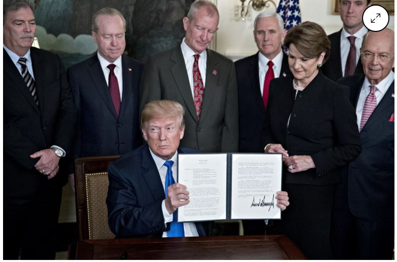   트럼프 전 대통령이 2018년 대중 관세 부과에 서명한 후 기자들에게 보여주는 장면. 사진=블룸버그통신