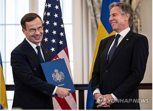   스웨덴 크리스테르손 총리(사진 왼쪽)와 토니 블링컨 美국무장관이 공식 가입문서를 전달하는 환하게 웃고 있다. 사진=AFP 연합뉴스