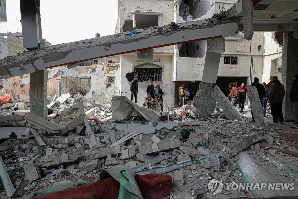 12일(현지시간) 팔레스타인인들이 가자지구 남부 라파에서 이스라엘군의 공습으로 파괴된 건물의 잔해를 살펴보고 있다. 하마스 측 가자지구 보건부는 이스라엘군의 공습으로 100명 이상의 팔레스타인인이 숨졌다고 밝혔다[신화=연합뉴스]