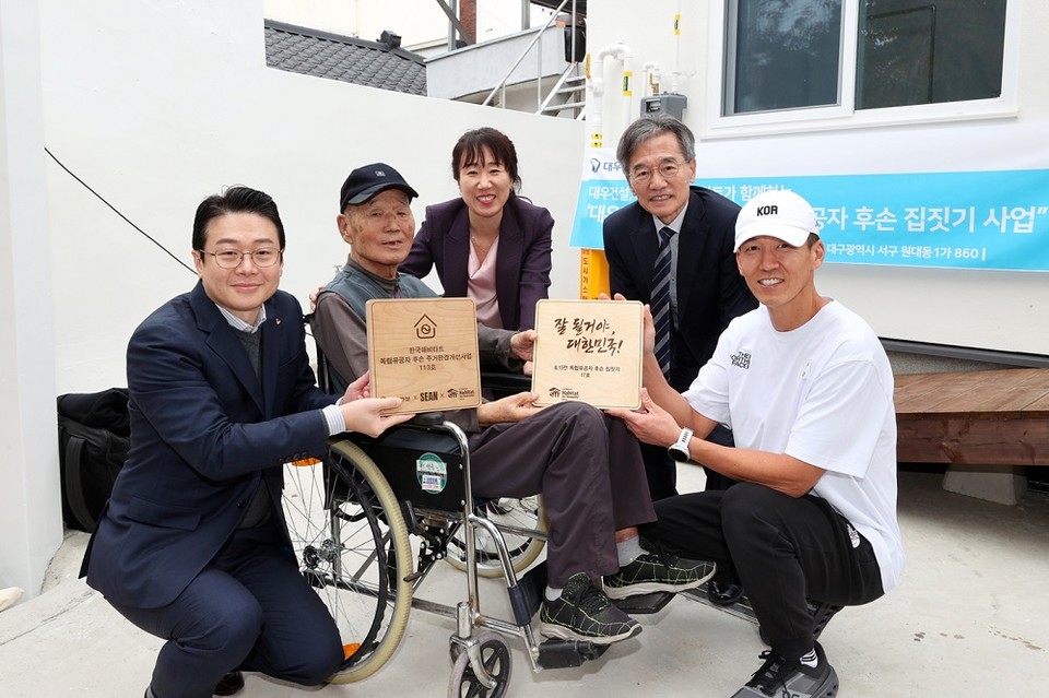 독립유공자 후손 집짓기 헌정식 참석 관계자들이 기념사진을 촬영하고 있다.