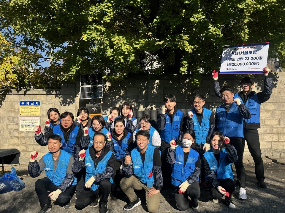 지난 14일 서울 용산구 서부이촌동 인근 주택가에서 사랑의 연탄 나르기 봉사활동에 참여한 SGI서울보증 직원들이 기념사진을 촬영하고 있다. / 사진제공=SGI서울보증